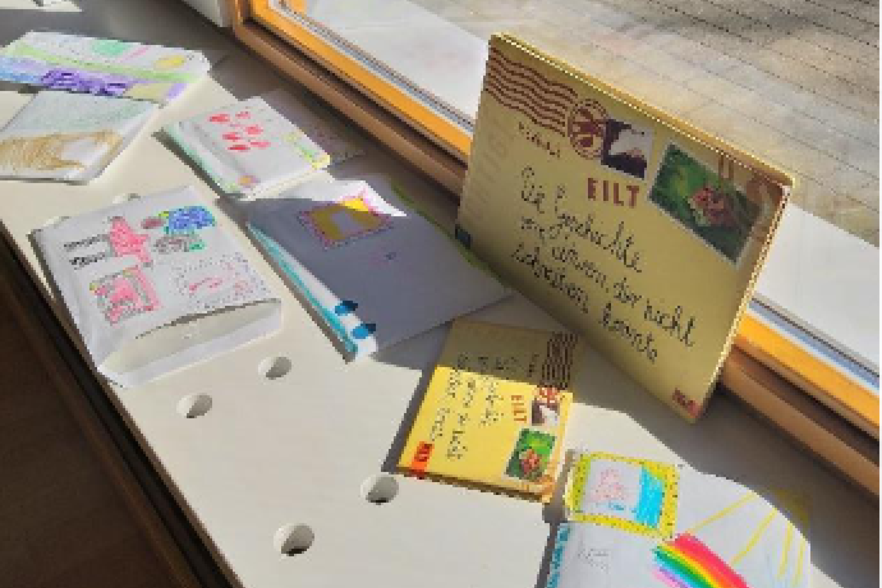 Briefe und selbstgemalte Kinderbilder auf einer Fensterbank
